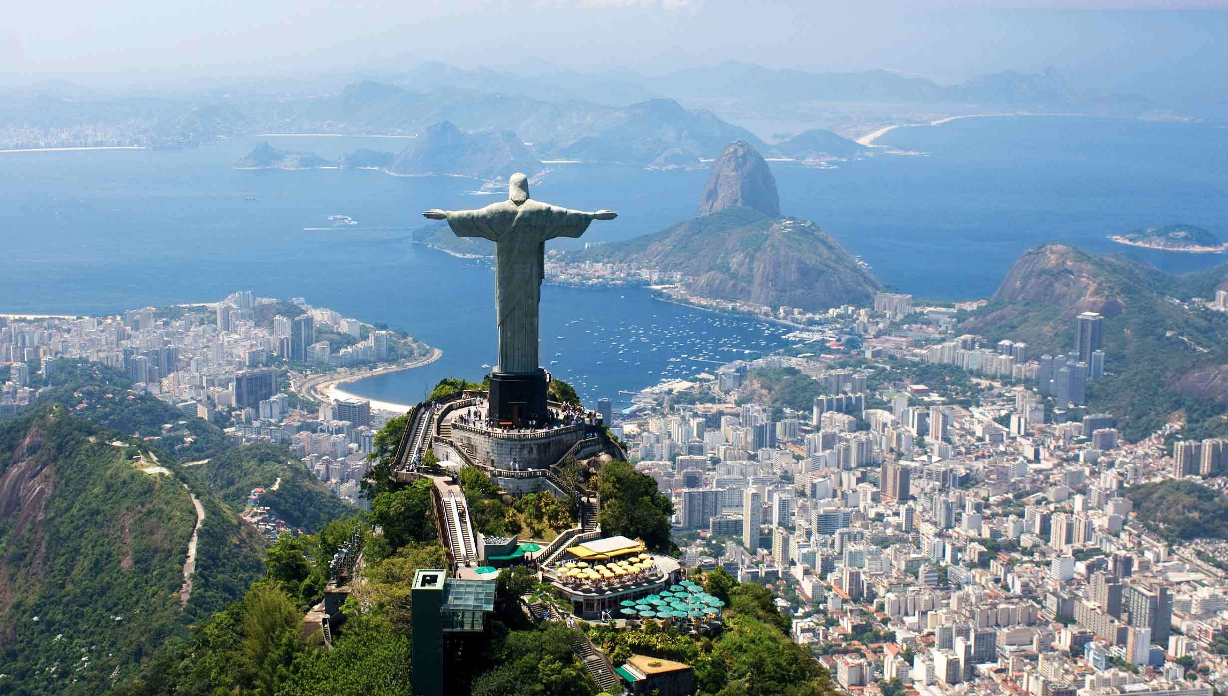 Christ the Redeemer overlooking Rio de Janeiro with Sugarloaf Mountain and the bay in the background | MSC Cruises Christ the Redeemer overlooking Rio de Janeiro with Sugarloaf Mountain and the bay in the background | MSC Cruises