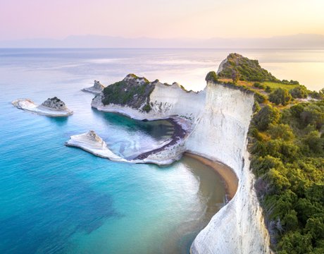 Dramatic white cliffs and turquoise waters at sunset on a serene coastline | MSC Cruises