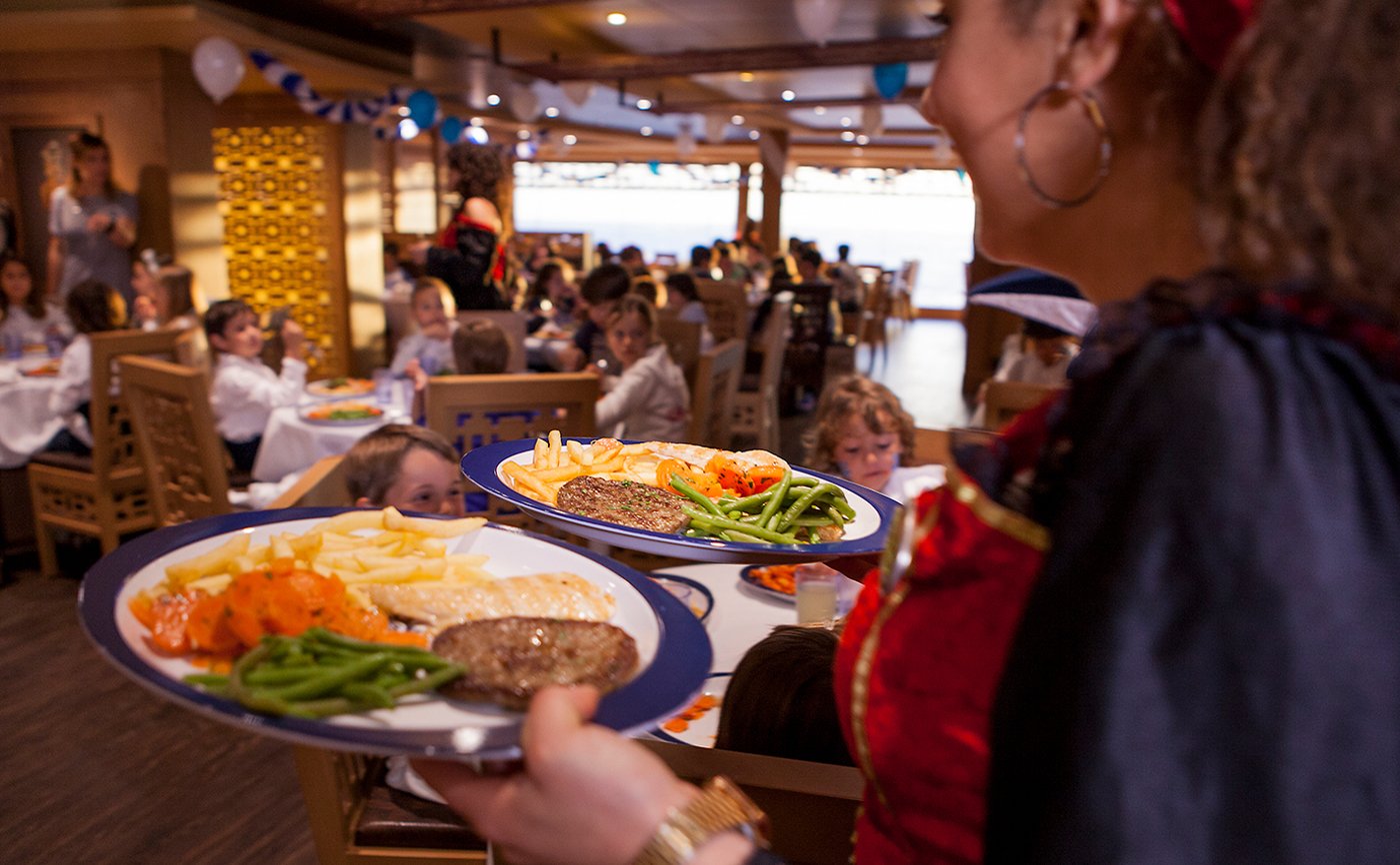 A vibrant dining area on a cruise ship with plates of gourmet food being served | MSC Cruises