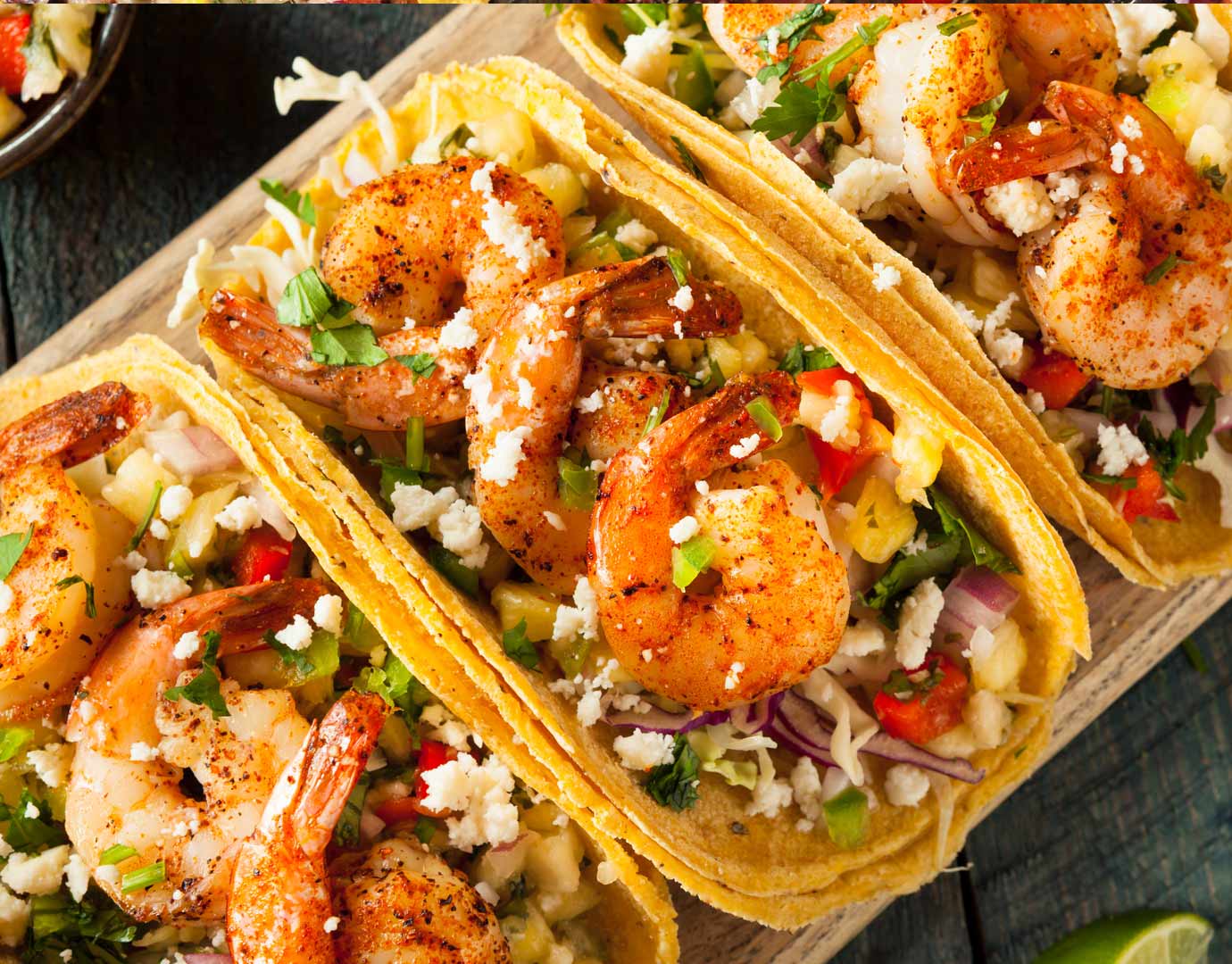 Grilled shrimp tacos with fresh toppings on a wooden platter | MSC Cruises Grilled shrimp tacos with fresh toppings on a wooden platter | MSC Cruises