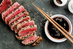 Sliced sesame-crusted tuna with soy sauce and chopsticks | MSC Cruises