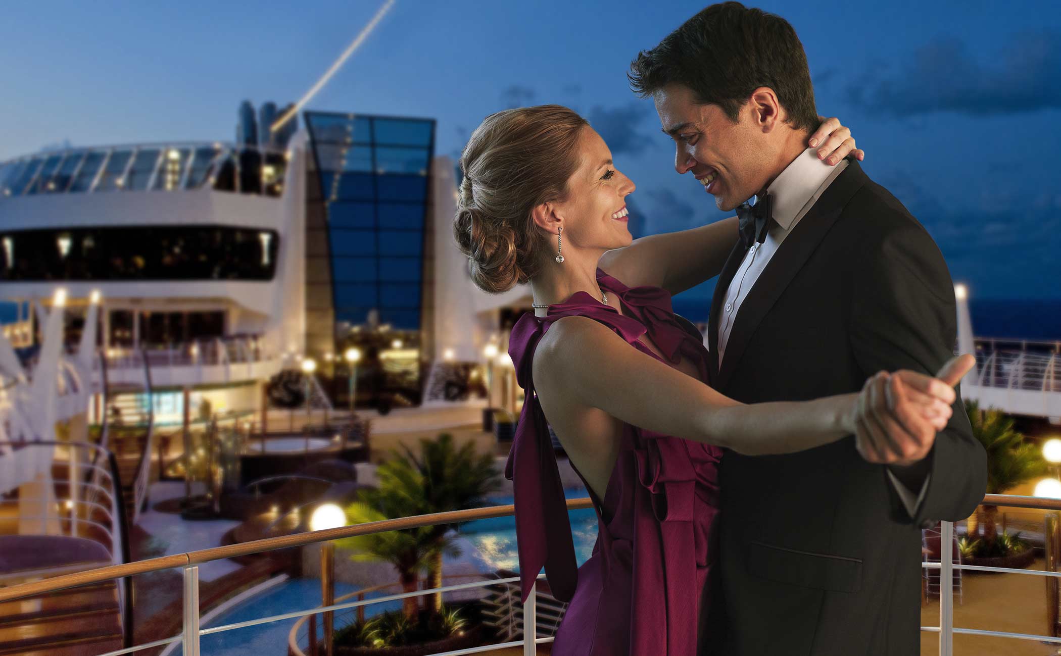 Elegantly dressed couple dancing on a cruise ship deck under the evening sky | MSC Cruises